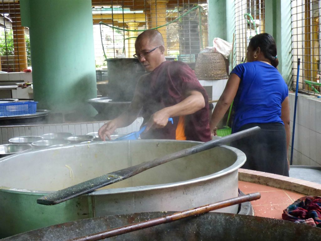 BAGO - een vrouw en een monnik koken in de keuken van het Kha Khat Wain Kyaung klooster