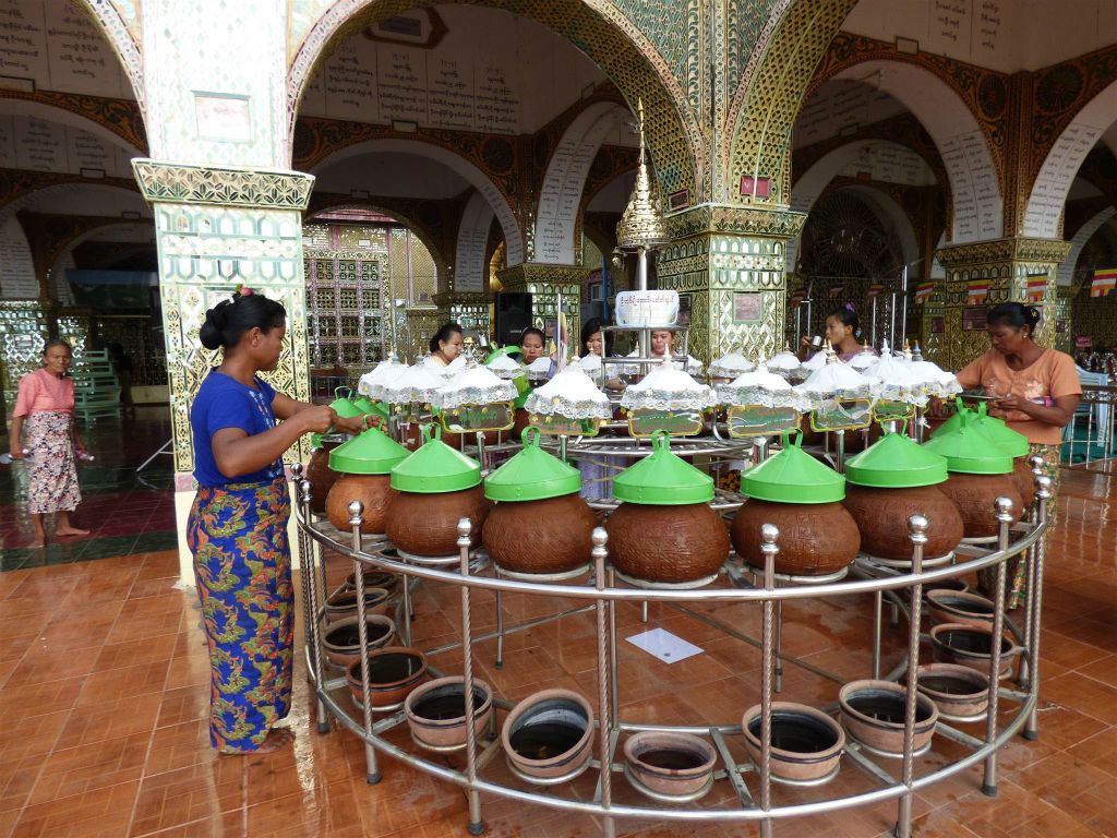 MANDALAY - enkele Myanmarezen drinken water uit een kan bij het Mandalay Hill complex