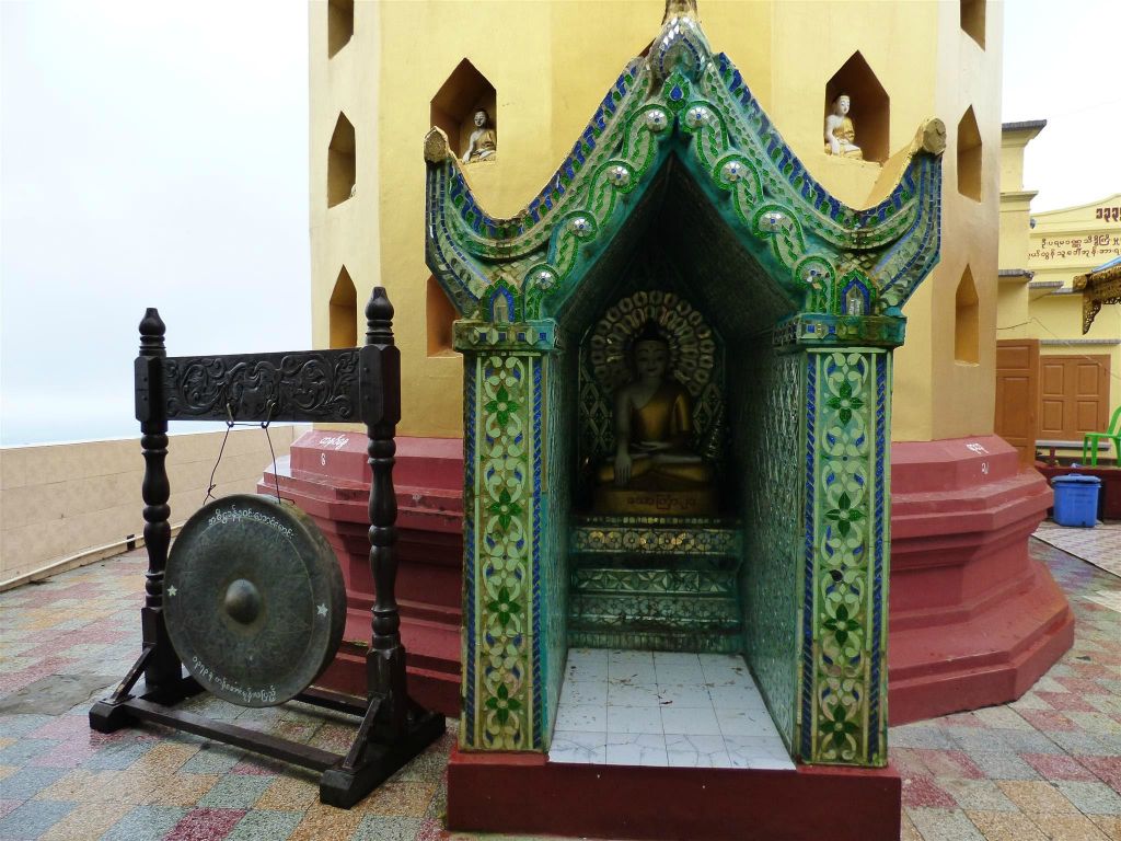 BAGAN -> MEIKTILA - een gong en een boeddhabeeld bij het Taung Kalat klooster op de heilige berg Mount Popa