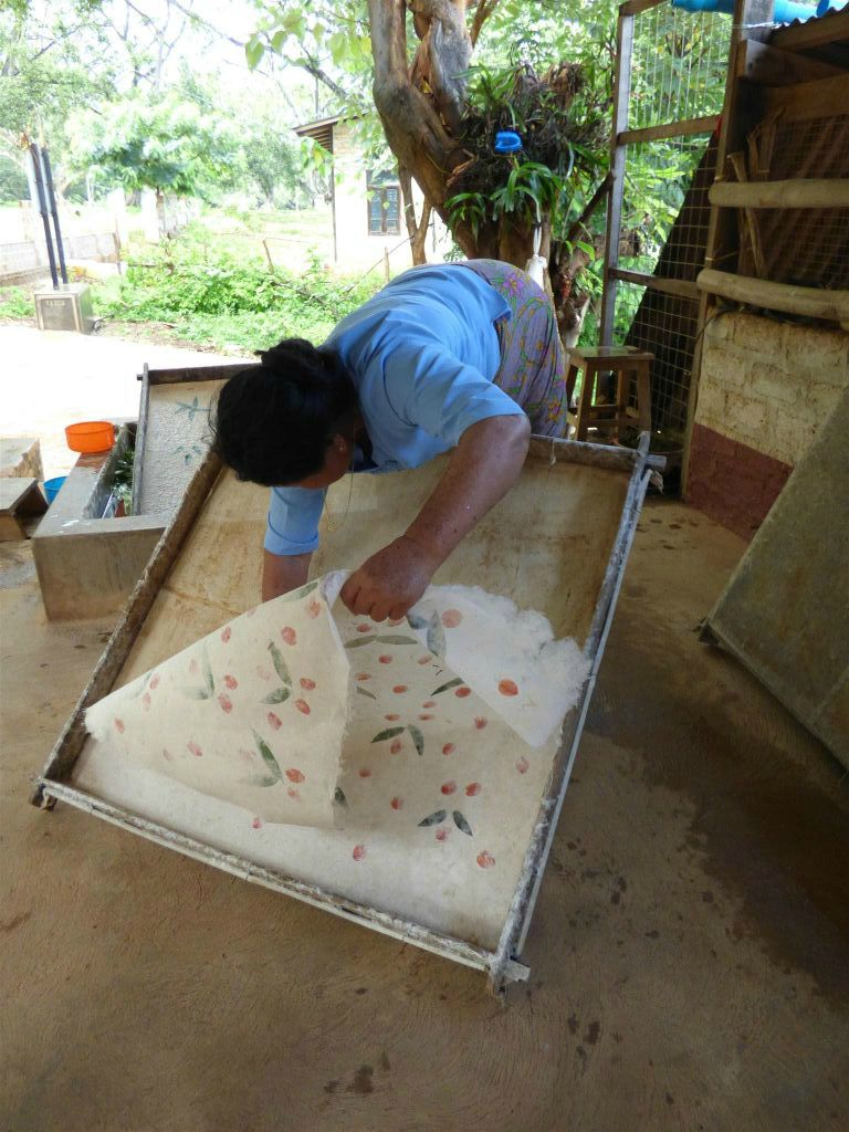 PINDAYA -> KALAW - een vrouw in een papieren paraplu werkplaats haalt het papier los van een vorm