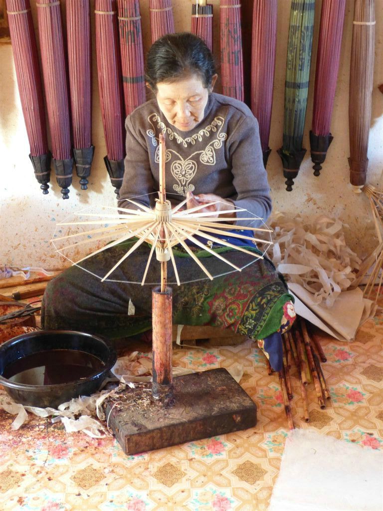 PINDAYA -> KALAW - een vrouw in een papieren paraplu werkplaats bezig met het assembleren van een paraplu