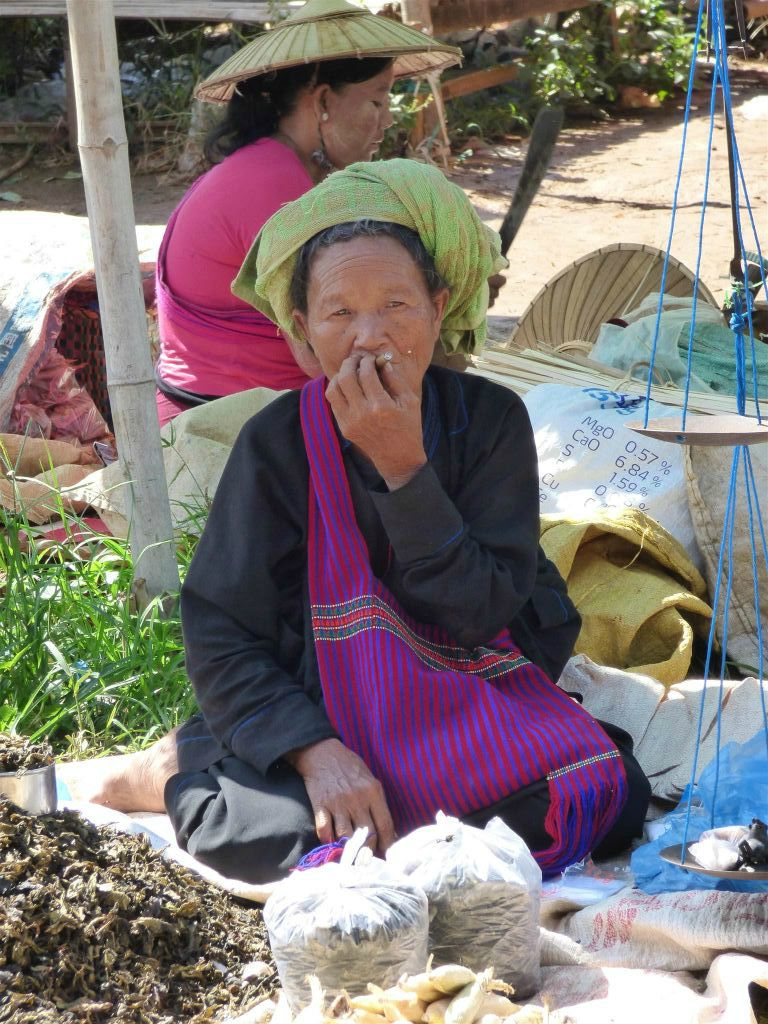 INLE MEER - een vrouw met een sigaar op een lokale markt bij Hpaung Daw Oo pagode