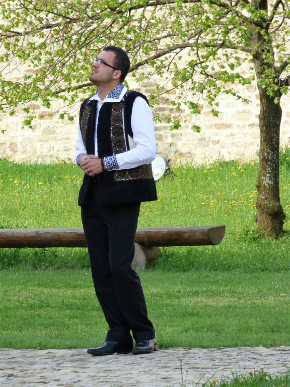 SUCEVITA - een kerkganger in traditionele klederdracht bij het Sucevita klooster uit 1585