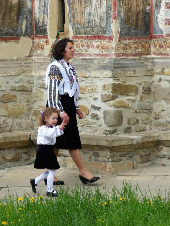 VATRA MOLDOVITEI - een Roemeense met dochter in traditionele klederdracht bij het Moldovita klooster uit 1532