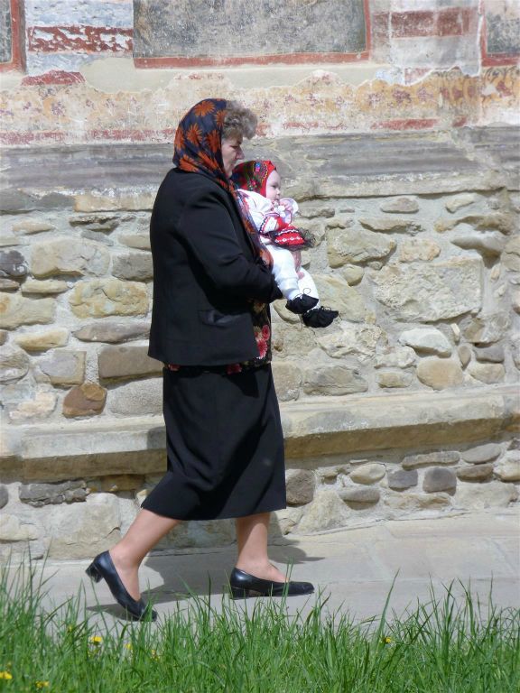 VATRA MOLDOVITEI - een Roemeense met kleindochter in traditionele klederdracht bij het Moldovita klooster uit 1532