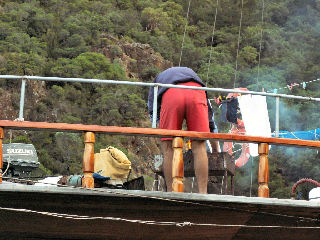 DALYAN - de kok die vis/kip aan het klaarmaken is op de barbeque op onze boot