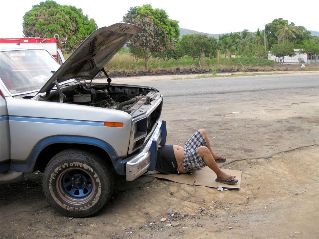 LIANOS -> CIUDAD BOLĺVAR - Venezolaan ligt onder zijn auto