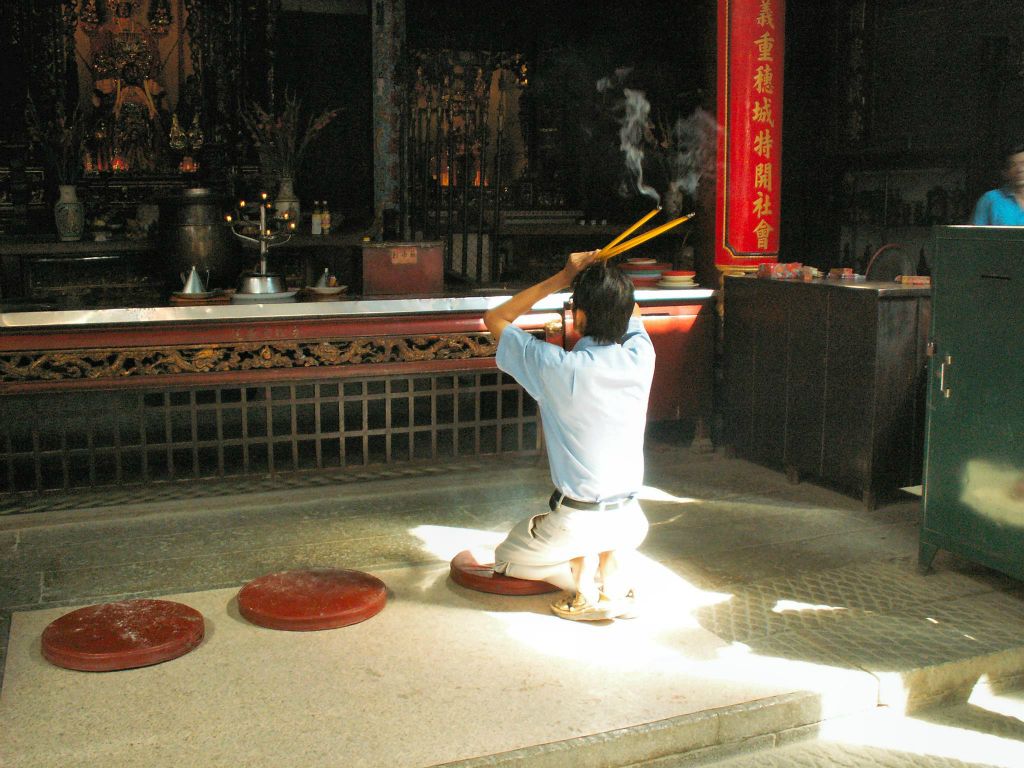 SAIGON - een man aan het bidden bij een Chinese tempel