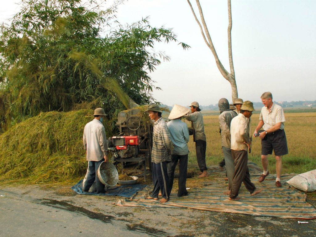 SAIGON - enkele mensen aan het werk bij een rijstveld
