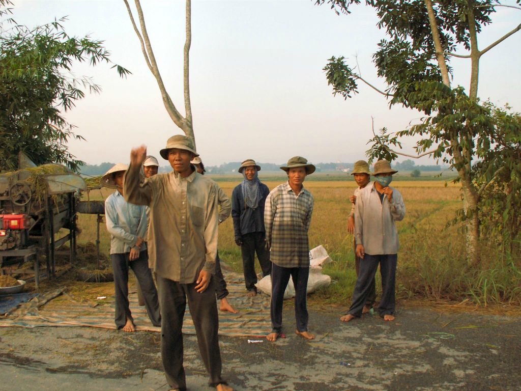 SAIGON - enkele mensen aan het werk bij een rijstveld