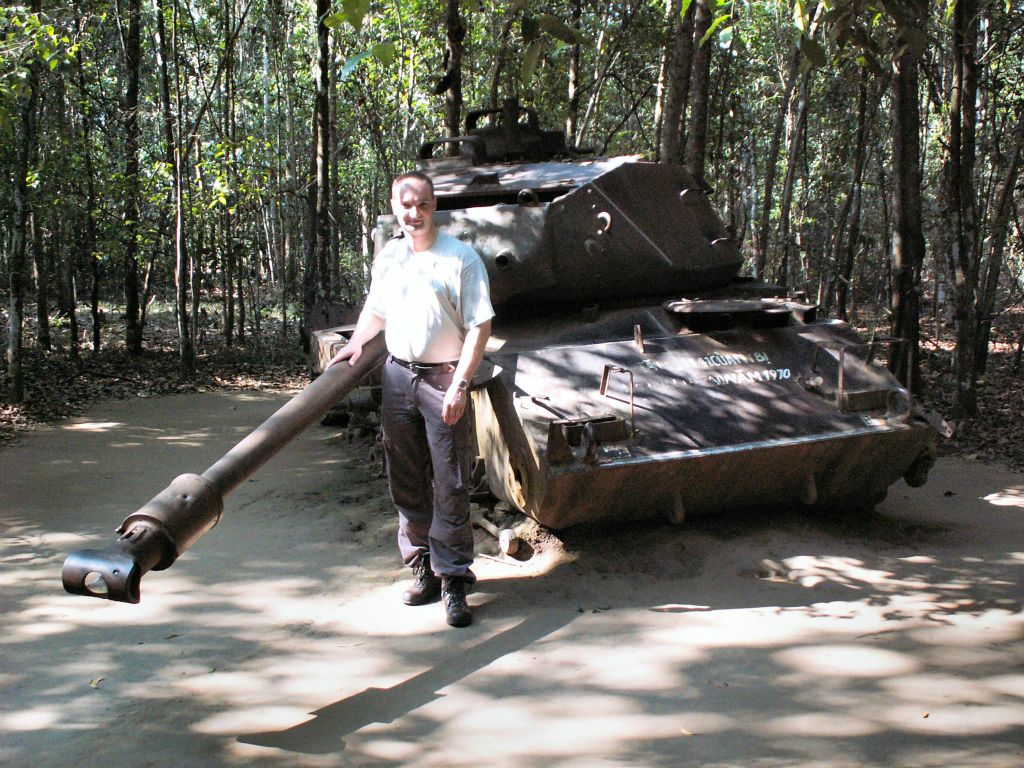 SAIGON - Carlos bij een gesneuvelde tank bij het tunnelcomplex van Củ Chi