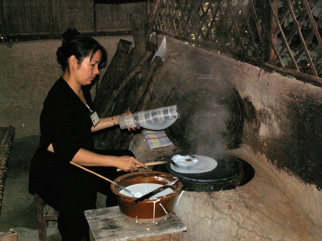 SAIGON - een vrouw die rijstwafels aan het maken is