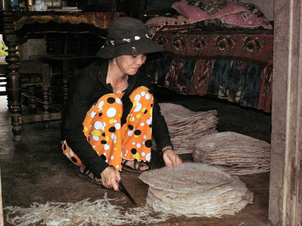 QUINHON -> HOI AN - het bijsnijden van vellen kroepoek in een kroepoek fabriekje