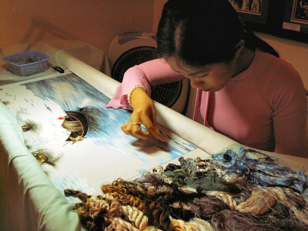 DA NANG - een vrouw die aan het borduren is bij het Cham Pa museum
