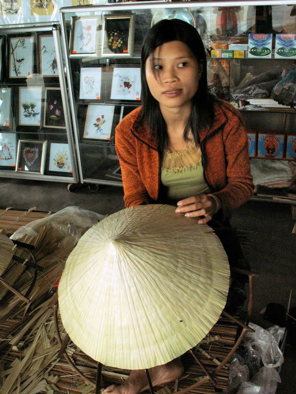 HUÉ - een vrouw die Vietnamese hoedjes aan het maken is