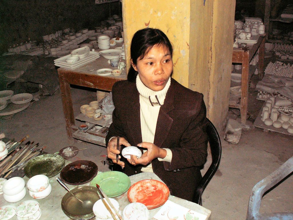 HALONG BAY ->  HANOI - een vrouw die aardewerk beschilderd